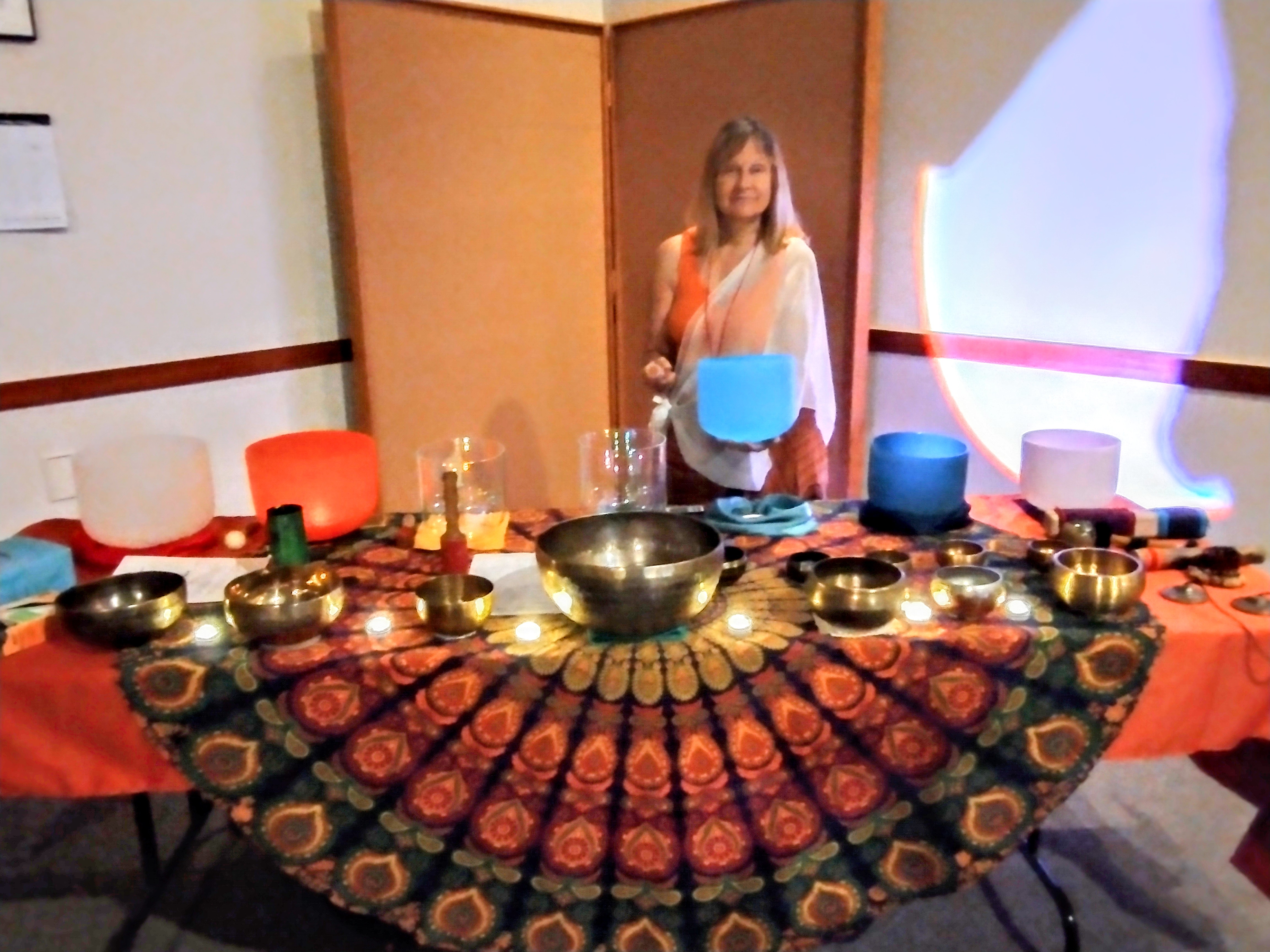 Kat Styrcula using multiple instruments at a sound bath at Sedona Public Library City of Peace event.